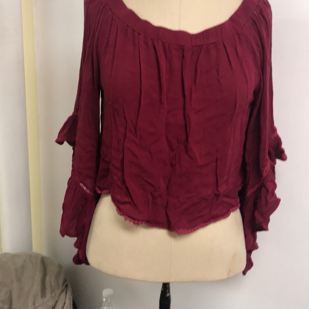 Maroon crop top with high low sleeves.